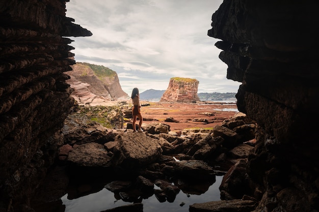 Woman going outside a cave at the basque coast