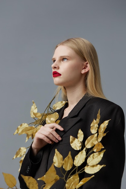 Woman golden leaves black blazer red lips studio model unaltered