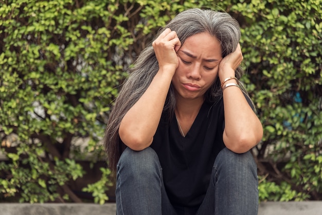 woman gray hair with worried stressed face expression looking down