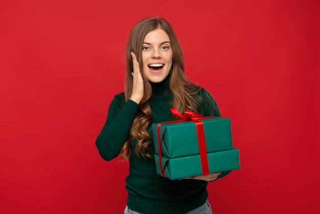 Woman in green sweater holding Christmas gift and yelling