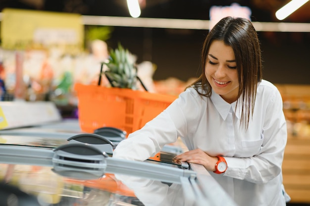 Woman grocery shopping and looking very happy