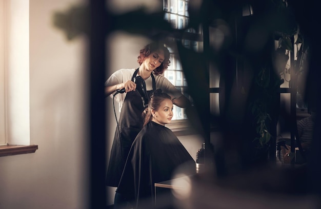 Photo woman hairdresser and blow hair of client for treatment haircare and professional for hairstyle beauty salon cosmetologist and hairstylist with equipment for grooming customer service and care