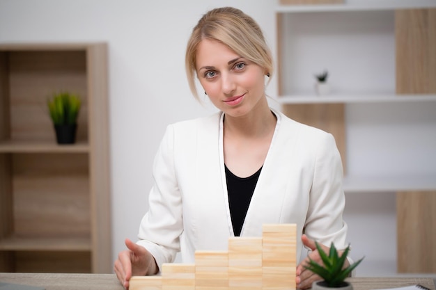 Woman hand arranging wood block stacking as step stair