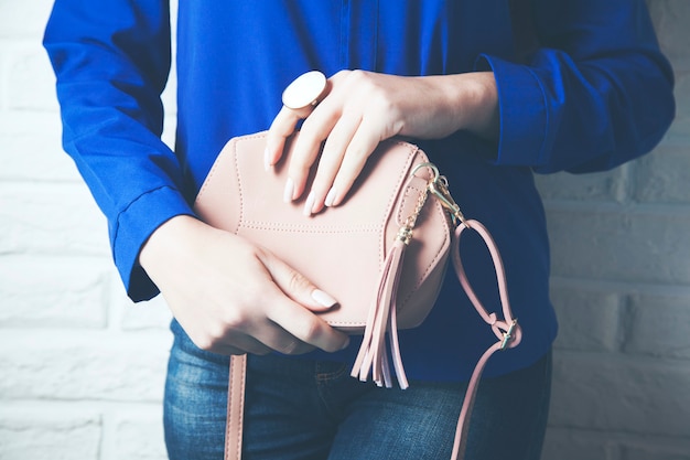 Woman hand bag in brick wall background