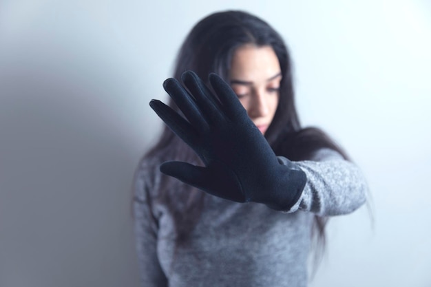 Woman hand black gloves stop sign