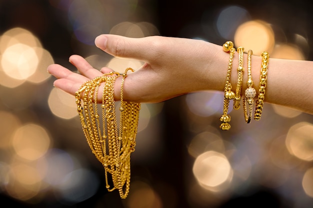 woman hand hold gold bracelet and necklace jewelry