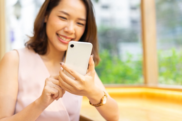 woman hand hold smartphone to playing application and reading content on social media network