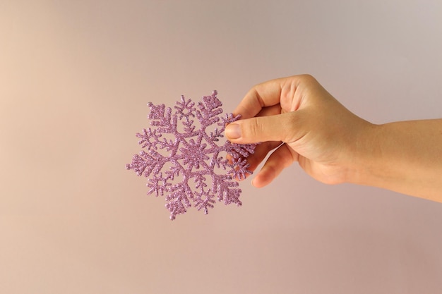 Woman hand holding big holiday snowflake