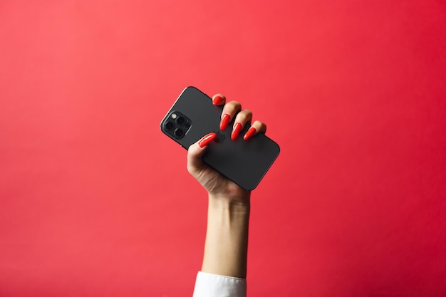 woman hand holding a blank screen smart phone on Red background with clipping path