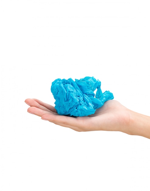 Woman hand holding blue plastic bag in ball composition isolated on white background.