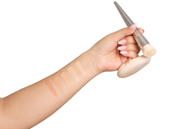 Woman hand holding brush and cosmetic puff. Isolated on a white background