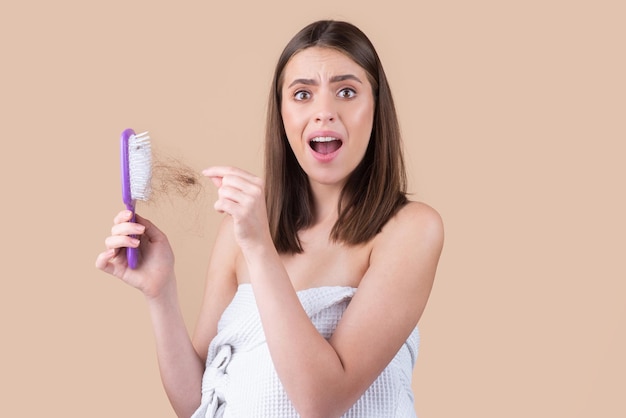 Woman hand holding comb with serious hair loss problem for health care shampoo