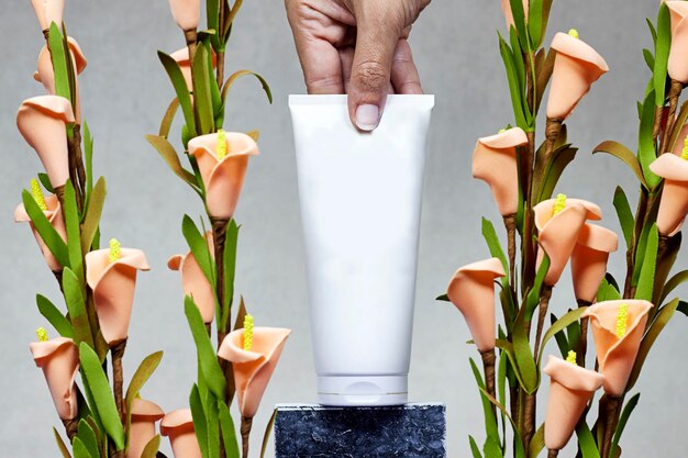 woman hand holding a Cream product above marble podium or stone beauty with calla lilies flowers