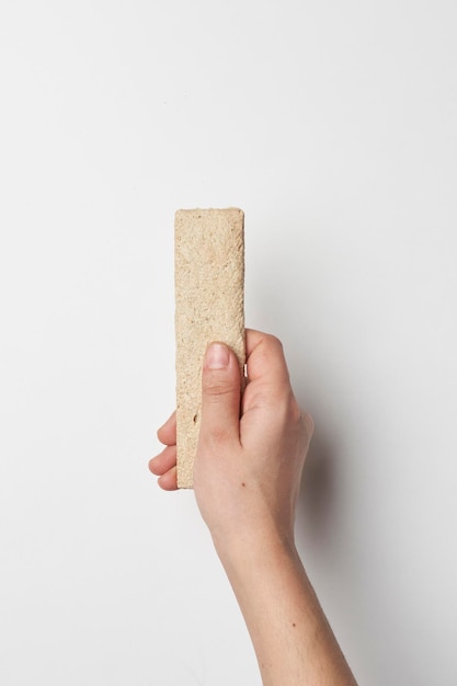 Woman hand holding crispy bread on white background dietary food close up