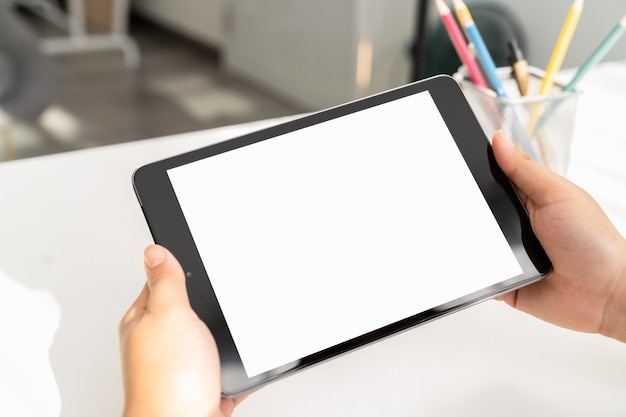 woman hand holding digital tablet on the table and the screen is blank.