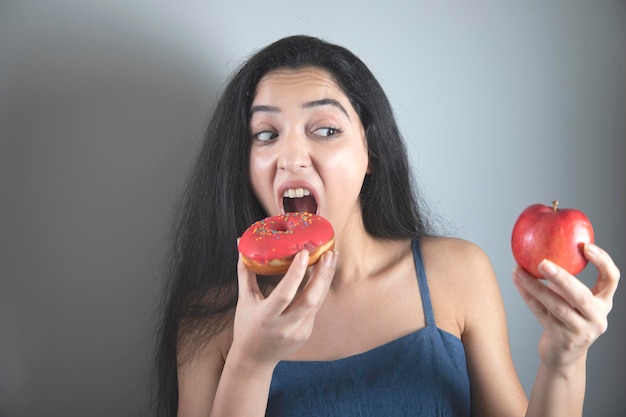 Woman hand holding Donut and apple