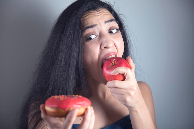 Woman hand holding Donut and apple