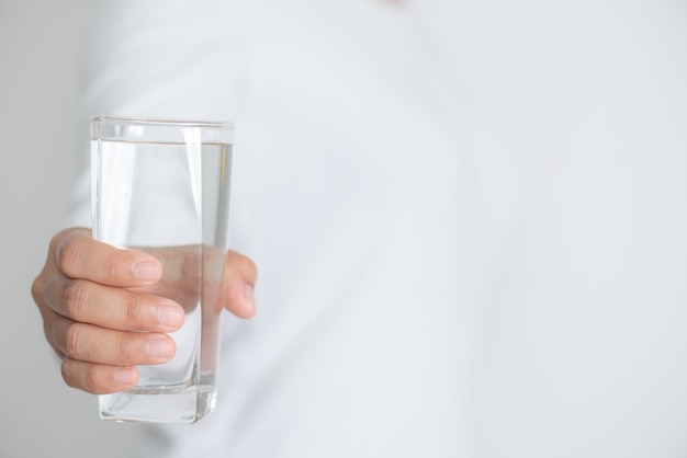 Woman hand holding a glass of drinking water.