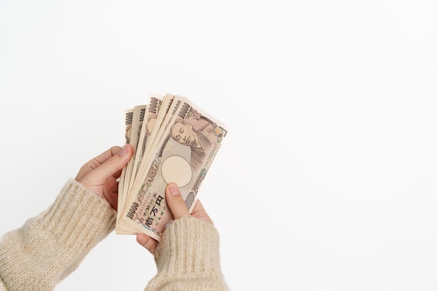 Woman hand holding Japanese Yen banknote stack Thousand Yen money Japan cash Tax Recession Economy Inflation Investment finance and shopping payment concepts