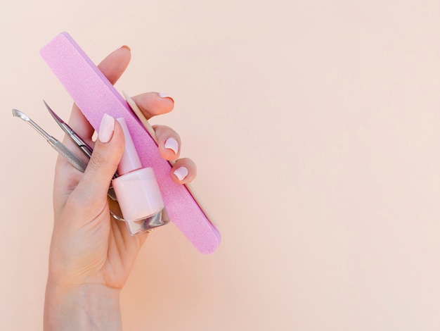 Woman hand holding manicure tools