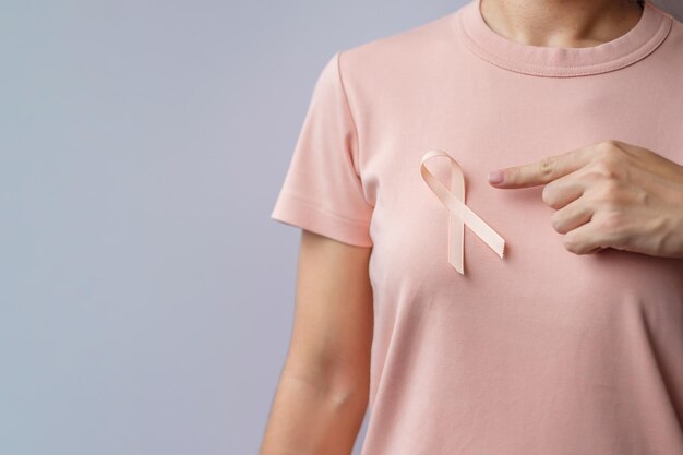 Woman hand holding Peach Ribbon for September Uterine Cancer Awareness month Healthcare and World cancer day concept