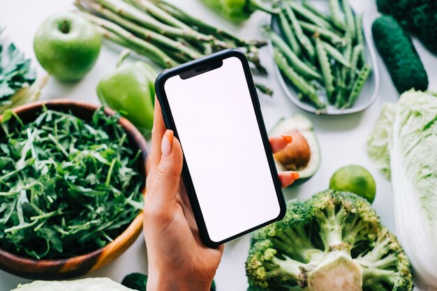 Woman hand holding smartphone with white screen