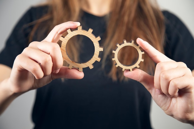 Woman hand holding wooden cog gear.