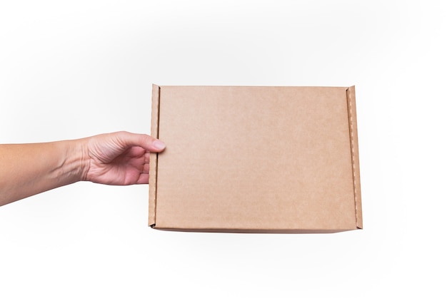 Woman hand holds brown Cardboard Carton box, flat, isolated