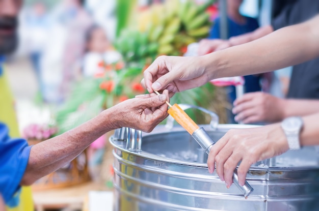 Woman hand is giving the elderly man ice cream