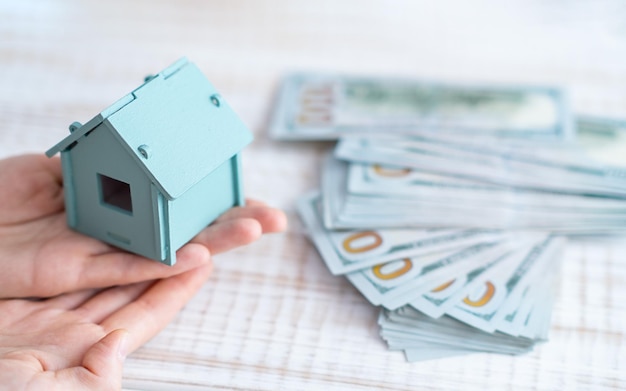 Woman hand key with house model on desk home loan