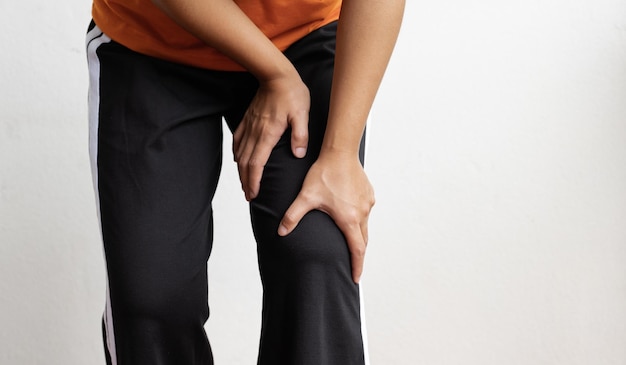 Woman hand massage physiotherapy her knee is sore and numb, exhausted, tingling. Guillain-Barre Syndrome, a side effect of the Covid vaccination.