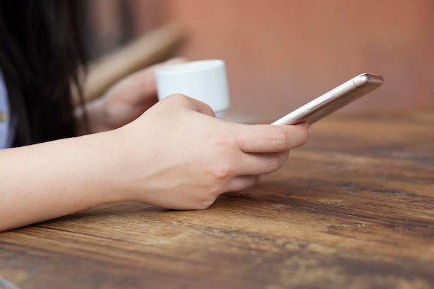 Woman hand phone and coffee