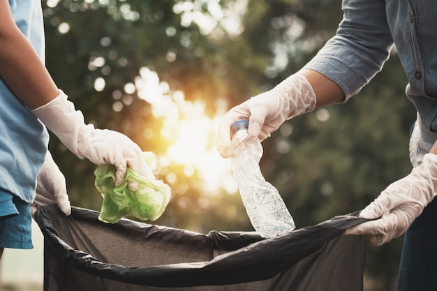 Woman hand picking up garbage plastic for cleaning at park