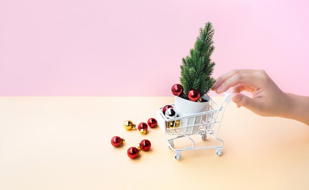 Woman hand pushing mock up cart or trolley and christmas ornament