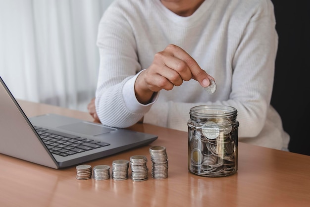 Woman hand putting money coin into piggy for saving money wealth and financial concept