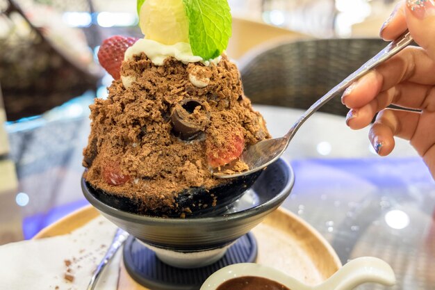 Woman hand scoop bingsu dessert ice cream chocolate