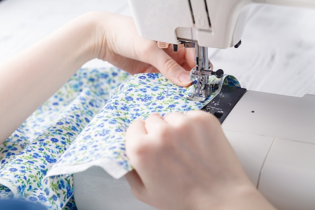 Woman hand sewn fabric on sewing machine.