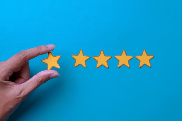 Woman hand showing on five star excellent rating on blue background Customer experience concept