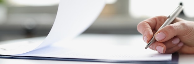 Woman hand signing documents on clipboard with ballpoint pen closeup conclusion of contracts