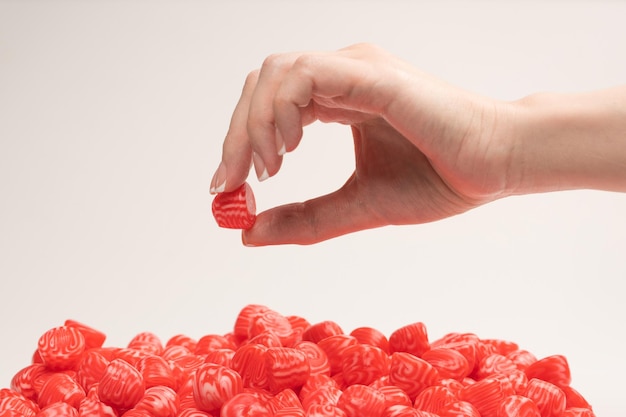 Woman hand takes a jelly candy on white background