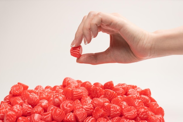 Woman hand takes a jelly candy on white background