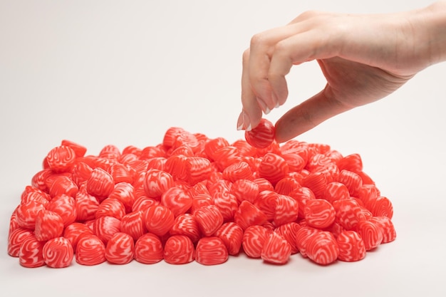 Woman hand takes a jelly candy on white background