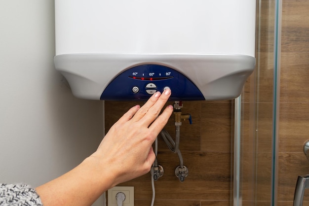 Woman hand turn on water heater energy economic