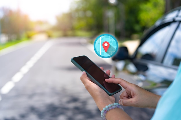 Woman hand use smartphone to find the way with gps on the road and car