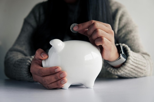 Woman hand and white piggy bank to saving money concept budget financial