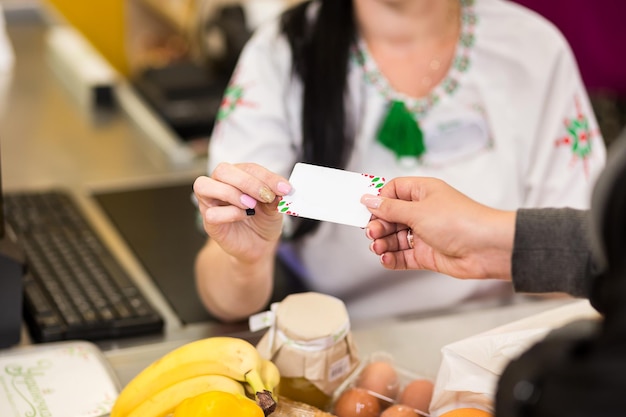 Woman hand with credit card swipe through terminal for sale in market Shopping and retail concept