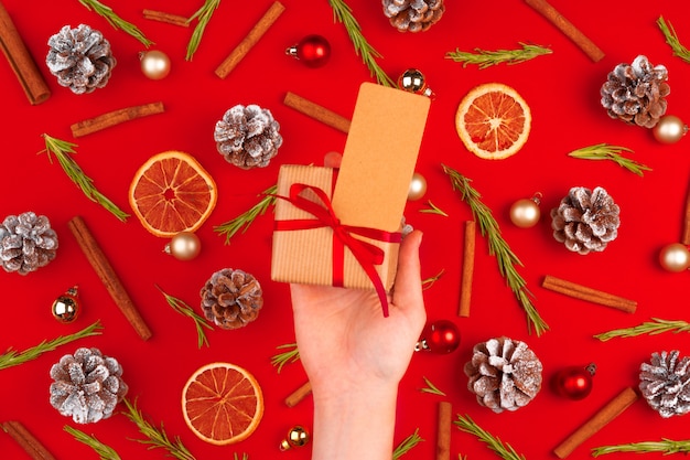 Woman hand with gift on decorated christmas background