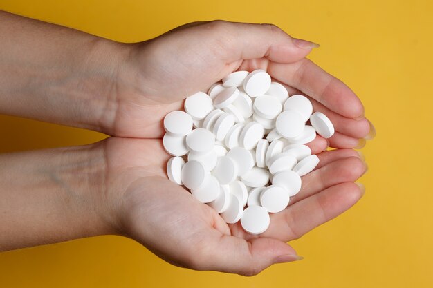 Woman hand with pills medicine tablets in her hands. Healthcare, medical supplements concept