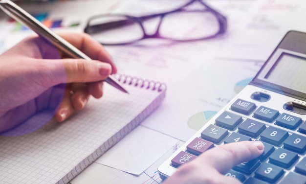 Photo woman hand working on calculator