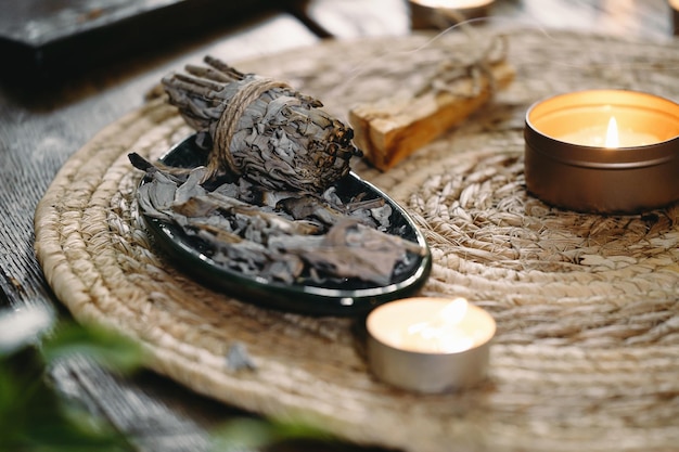 Woman hands burning white sage before ritual on cadle